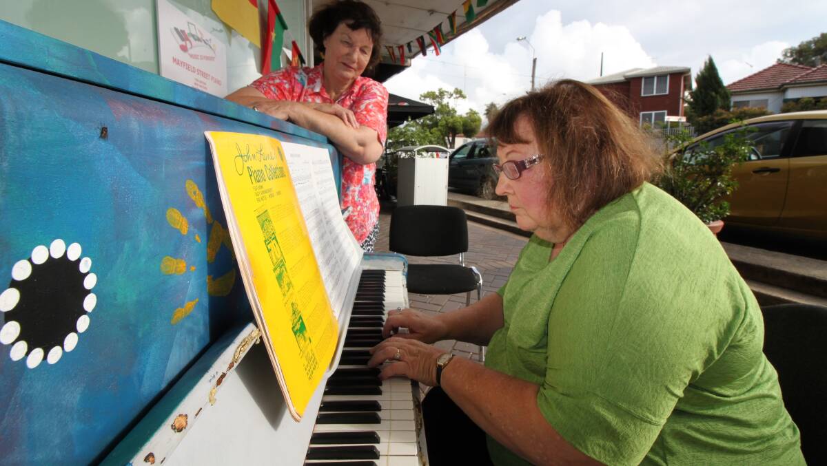 ACTIVATION: Julia Brougham watches on as Diana Bridgman tickles the ivories at a piano placed on a Mayfield West street to engage the community.