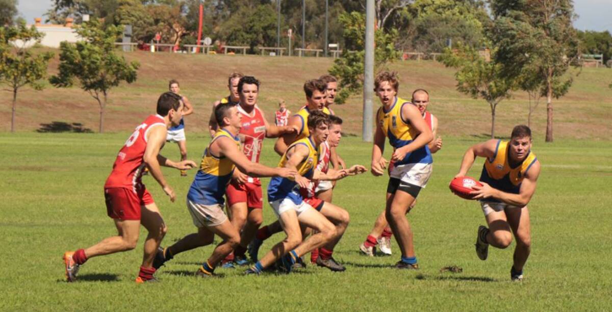 TAKE OFF: Former professional AFL player Craig Bird, pictured right with the ball, is back playing for the Nelson Bay Marlins. He featured in Saturday's round one game against Singleton.