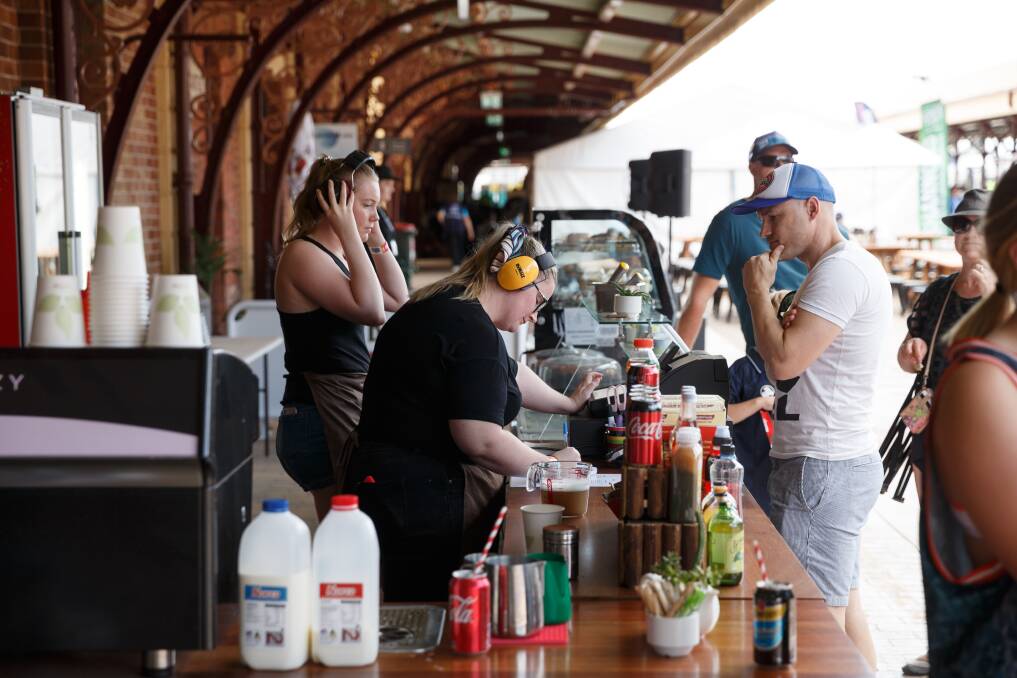 Staff take orders while wearing earmuffs at The Station Cafe at the old Newcastle railway station on day two of the Newcastle 500 V8 Supercars in 2018. Picture: Max Mason-Hubers 