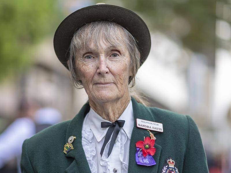 Sandra Davis wearing her father Bill Wharton's war medals during the Anzac Day march in Brisbane.
