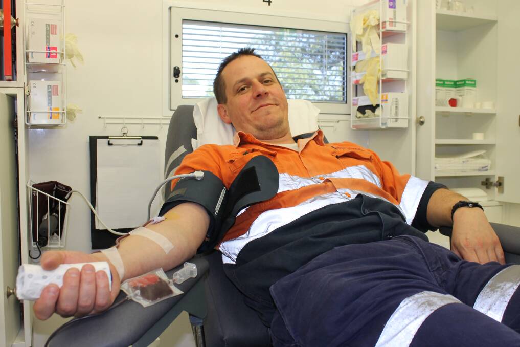 Dean Richardson donates blood in the new Australian Red Cross Blood Service mobile blood unit.