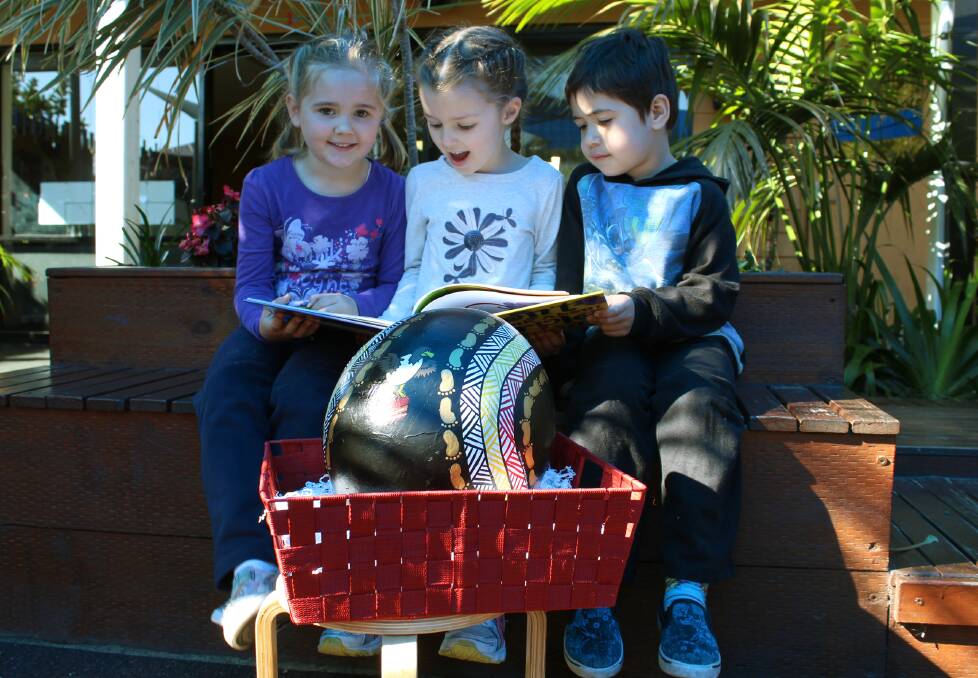WINGS OF WONDER: Mount Hutton Childcare Centre's Gabrielle Ollerton, 5, Elina McElhone, 4, and Neori Tokalolo, 4, read to the egg.