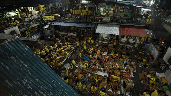 Some of the 3562 inmates sleep on any available space on the basketball court in jail in Manila, Philippines. The congestion is due to the war on drugs. Photo: Kate Geraghty
