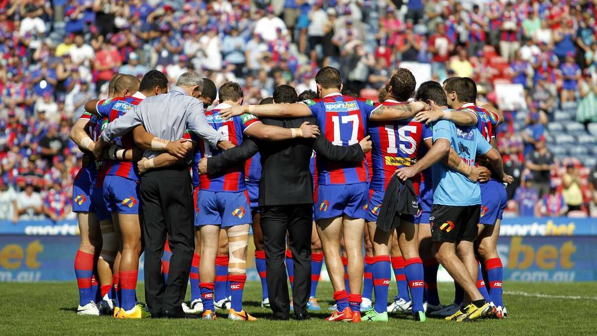 SOLIDARITY: Newcastle Knights players and staff huddle on the field in a minute of silence for injured player Alex McKinnon