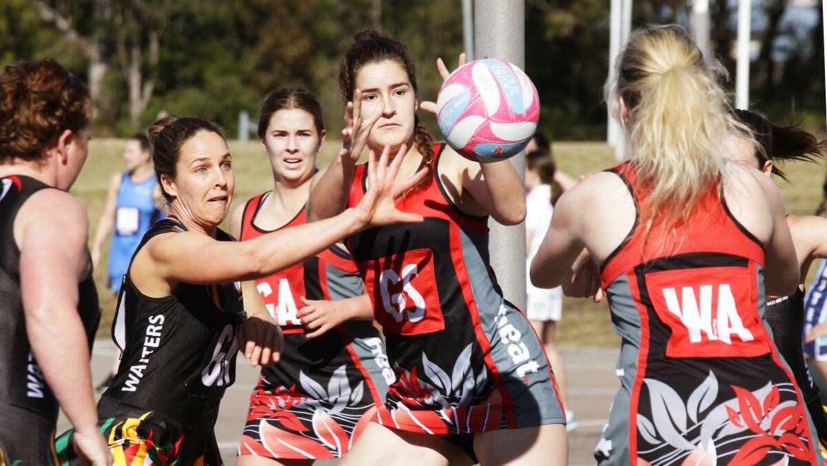 EYES ON THE BALL: Star shooter Claire Kowald (centre) was 'near perfect' for Heat as they climbed to a 26-point win over second-placed Watters. Picture: Kerrie Brady