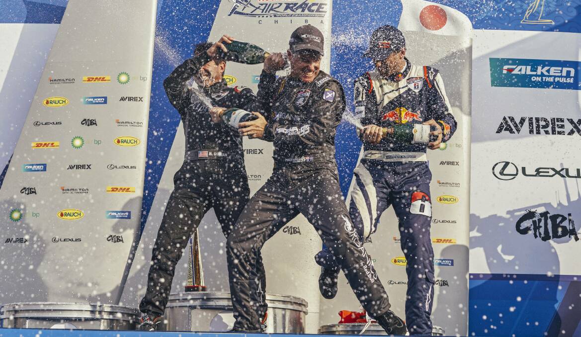 Matt Hall is sprayed with champagne by Michael Goulian and Martin Sonka after his victory in the skies above Chiba. The win moves him into the top spot in the Championship. Picture: Balazs Gardi