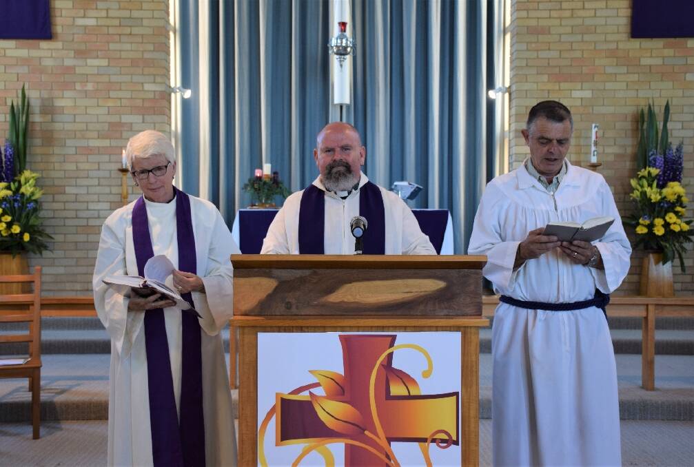 PLANTING SEEDS: Reverend Greg Colby (centre) walked the hard road on his way to finding faith, hope and a perfect patch to garden in Belmont North and Redhead. Picture: Newcastle Anglican Church