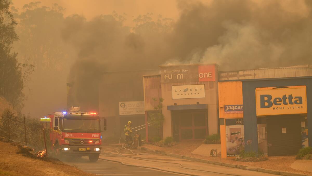 Firefighters work to save businesses at Batemans Bay. Picture: Supplied