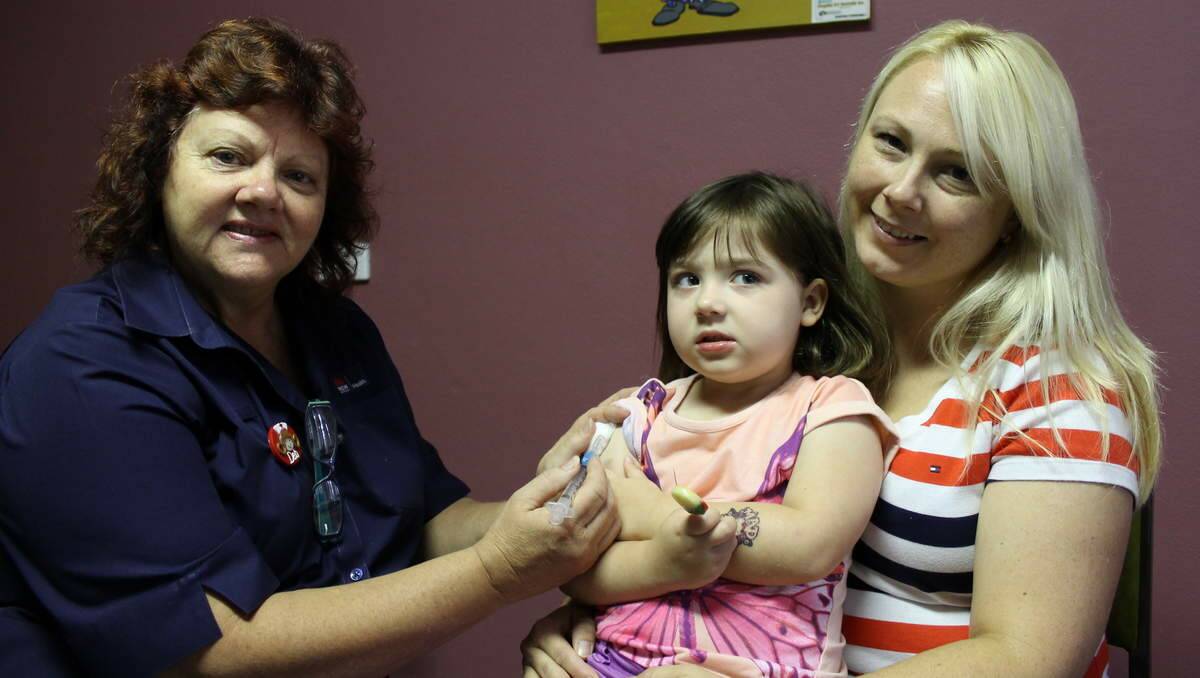 PROTECTION: Belmont Kaleidoscope Paediatric Clinic Nurse Deb Mollison vaccinates Isabella Watsford, 4, while her mother Lisa Rees-Watsford comforts her. Picture: Madeline Link