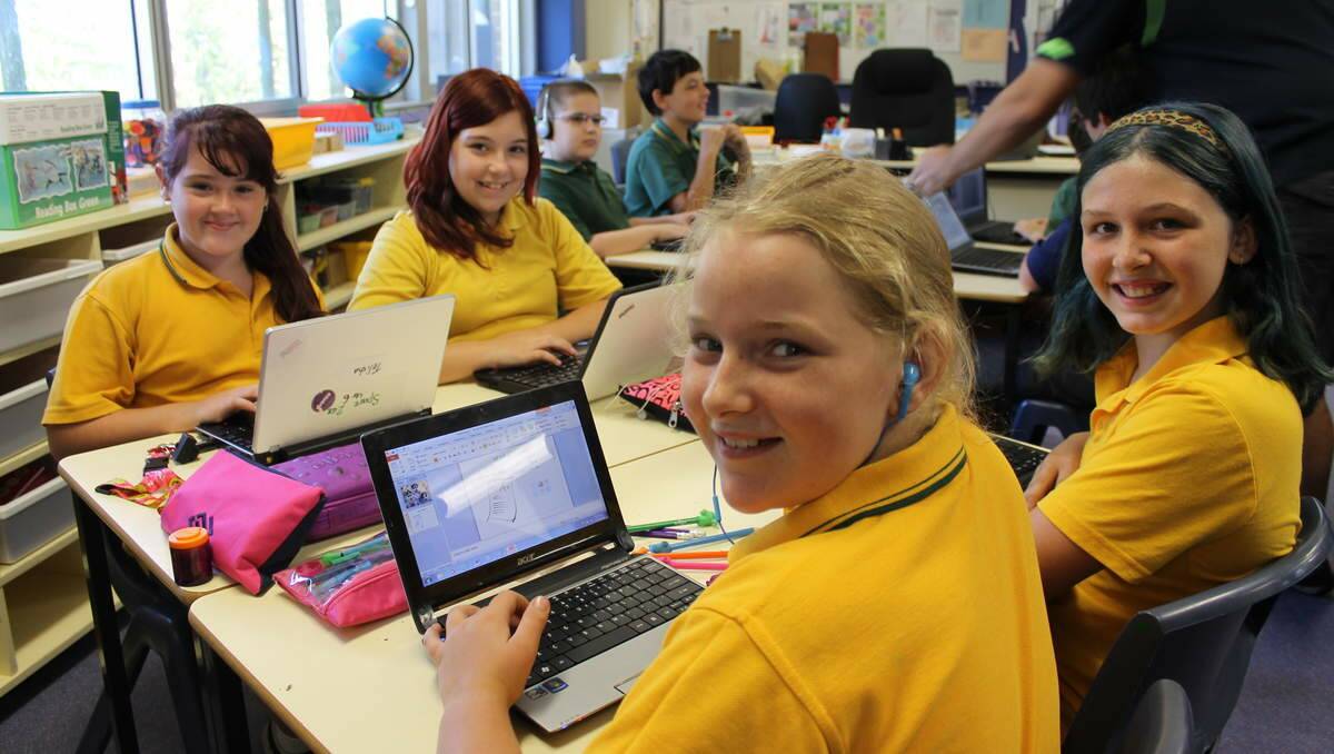 Warners Bay Primary School students Hailie McClelland, 11, Brittney Roberts, 11, Trinity Coker, 11, and Telisha McGinley, 10, of class 6K use  their computers in the One to One program as part of the Bring Your Own Device Policy.