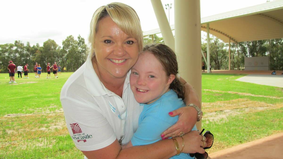 LOVING CARE: Volunteer Leah Farrell, from Blackhill, and swimmer Megan Nay, 10, from Eleebana, on day one of the Special Olympics Junior National Games.