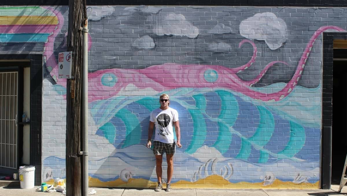 Artist Mitch Revs in front of a self-painted mural at his Newcastle West home.