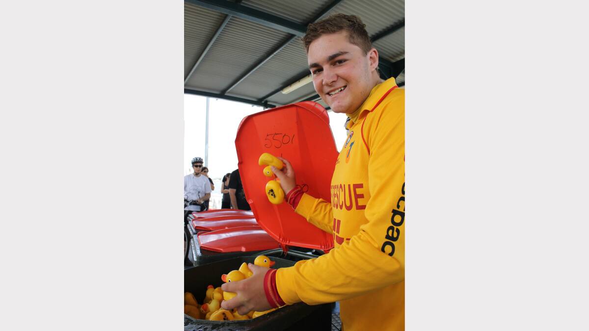 Nobbys Surf Life Saving Club volunteer Zach Donnelly helps out with the Duck 4 Dollars race in Newcastle harbour.
